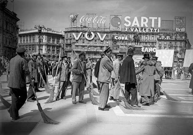 Comparse che interpretano degli spazzini fotografate in Piazza del Duomo durante la lavorazione di una scena del film Miracolo a Milano di Vittorio De Sica, 1951; ©ArchiviFarabola